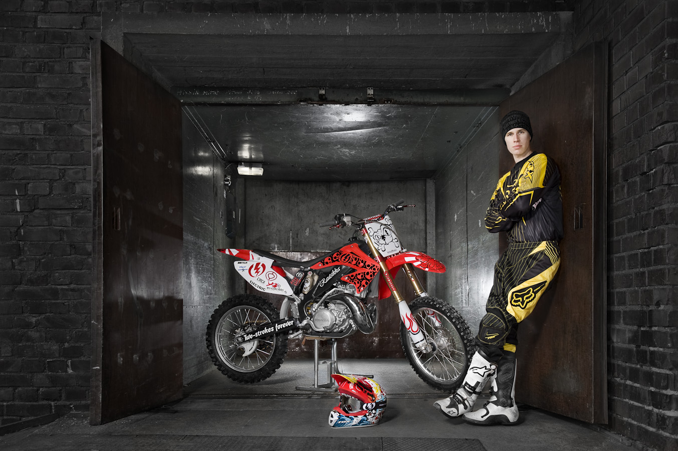 Motocrosspyörä ja kuljettaja autotallissa
